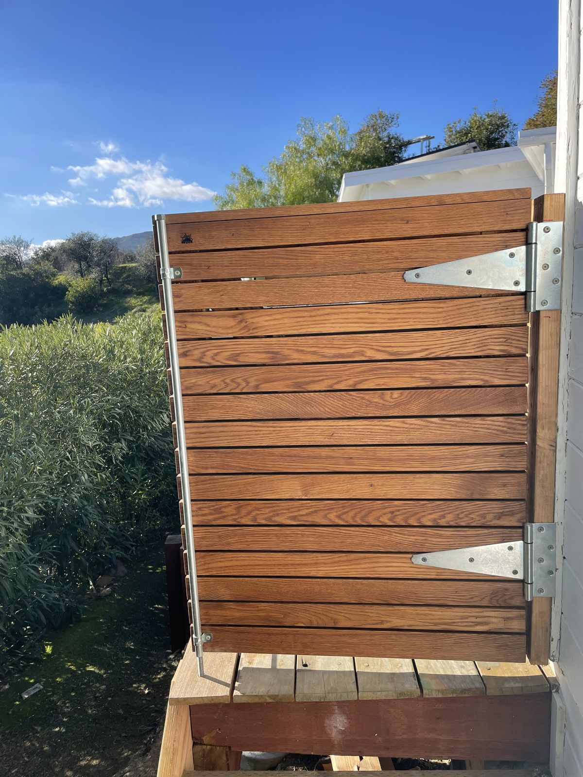 Hinged hardwood gate beside a deck