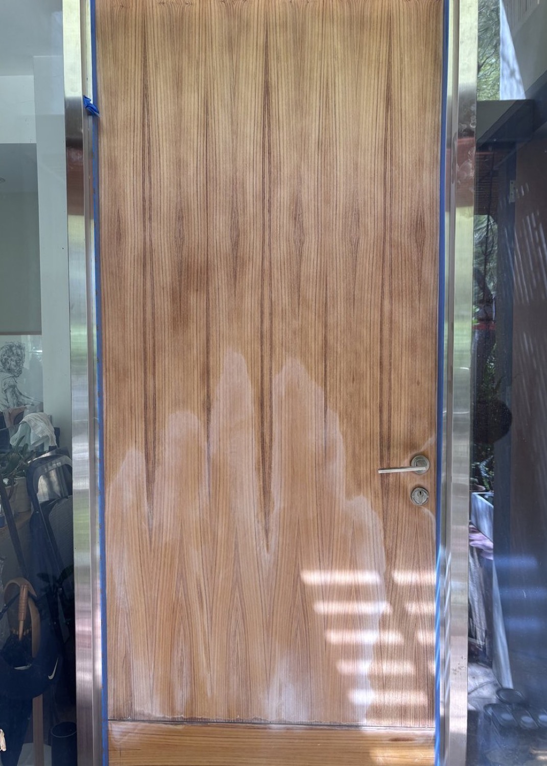 Solid timber entry door with sun-bleached, blotchy failed finish