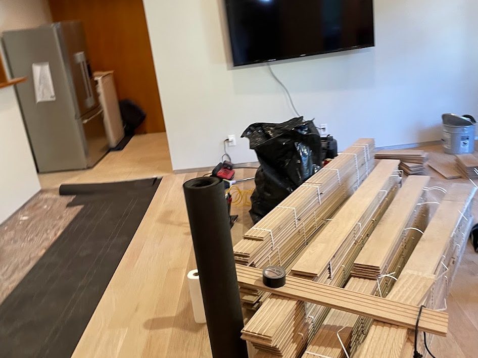 Flooring material and underlayment staged in the room before installation
