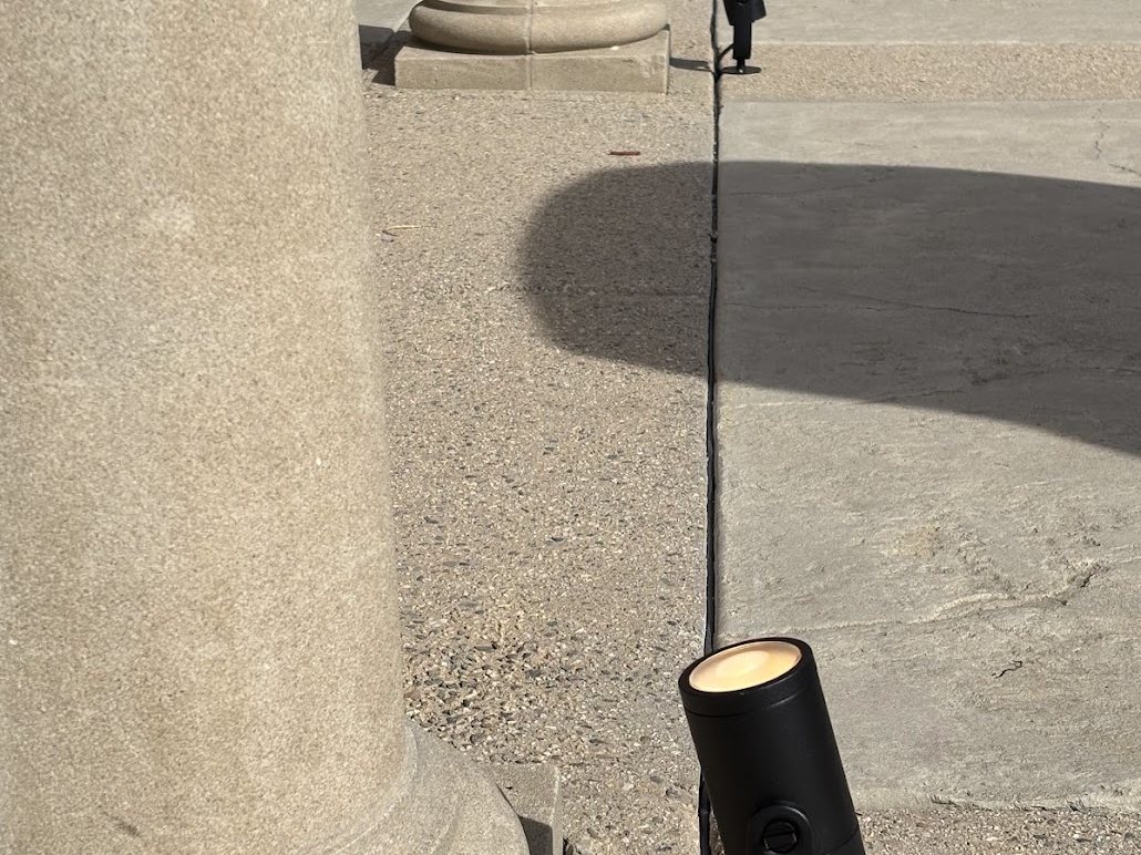 Adjustable uplight fixture set at the base of a column