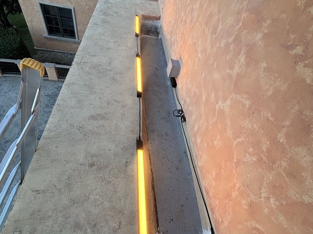 Amarant linear outdoor light fixture mounted along a wall coping